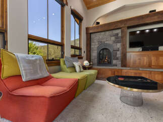 Experience ultimate relaxation in this cozy living room, featuring a vibrant sectional sofa and a stunning stone fireplace.