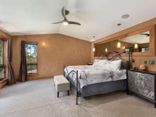 Experience luxurious mountain living in this stunning bedroom, featuring a king-size bed with elegant marble-patterned bedding.