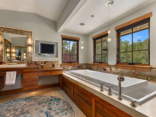 Indulge in luxury in this stunning bathroom featuring a deep soaking tub with a sleek faucet and a separate vanity area.