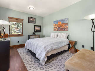 Experience comfort and style in this inviting bedroom, featuring a plush queen-size bed adorned with a textured white comforter.