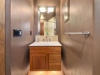 This bathroom features a charming wooden vanity with ample storage, complemented by a sleek white countertop and a modern faucet.
