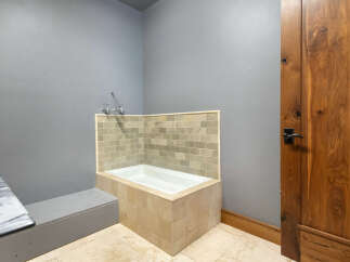 This modern bathroom features a built-in bathtub with elegant tile surround, perfect for a relaxing soak.