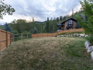 Nestled amidst a picturesque mountain landscape, this stunning stone and wood home offers a serene retreat.