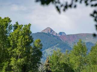 Discover breathtaking mountain views from this stunning property, nestled amidst lush greenery.