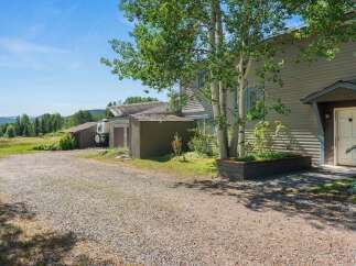 Discover this charming property featuring a main house with a welcoming entrance and a raised planter box.