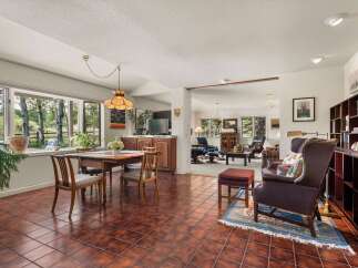 Enjoy a spacious and inviting living area with a dining space featuring a large window overlooking a serene natural landscape.