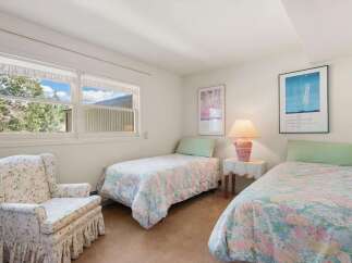 This charming bedroom features two cozy twin beds adorned with floral comforters, perfect for guests or family.