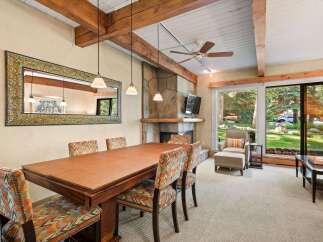 Experience elegant dining in this beautifully appointed space, featuring a large wooden table surrounded by chairs upholstered in a vibrant, geometric pattern.