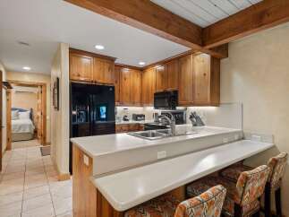 Experience the charm of this rustic kitchen, featuring warm wooden cabinetry and a sleek granite countertop.