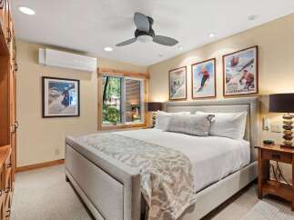 Experience the charm of this inviting bedroom, featuring a comfortable king-size bed adorned with crisp white linens and a decorative throw.
