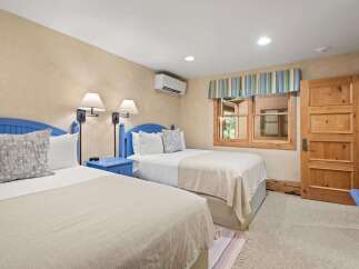 This charming bedroom features two comfortable beds with blue headboards, perfect for accommodating guests.