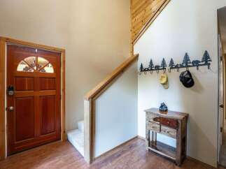 Step into a warm and inviting entryway featuring a beautiful wooden door with a decorative arched window.