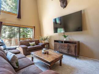 Experience rustic charm in this spacious living room, featuring a large sectional sofa perfect for cozy gatherings.