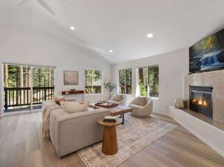 Experience modern living in this stunning living room, featuring a cozy fireplace and a large TV perfect for entertainment.