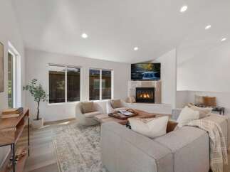 Experience modern living in this spacious living room, featuring a cozy fireplace and a large flat-screen TV perfect for entertainment.