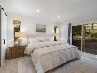 Experience serene living in this beautifully appointed bedroom, featuring a plush king-sized bed and elegant neutral-toned bedding.