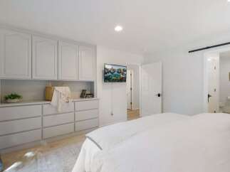 This bedroom features a built-in wardrobe with ample storage and a mounted television for entertainment.