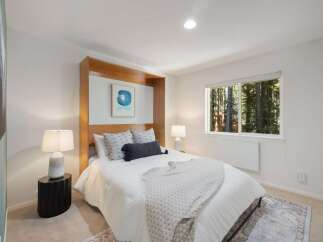 Experience serene living in this charming bedroom, featuring a comfortable queen-size bed with plush bedding and decorative pillows.