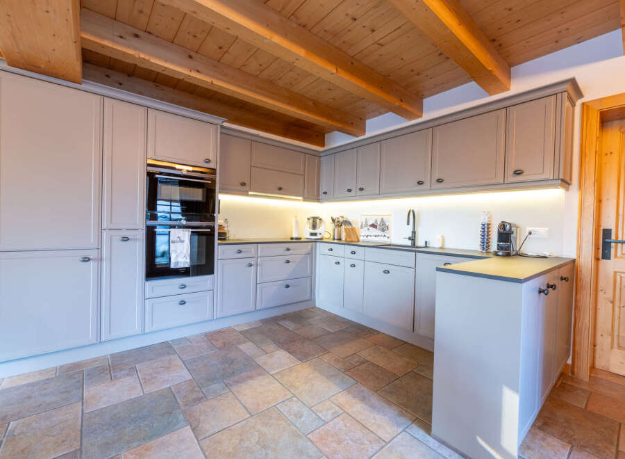 Experience modern alpine living in this beautifully appointed kitchen, featuring sleek grey cabinetry and integrated appliances.