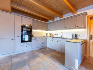 Experience modern alpine living in this beautifully appointed kitchen, featuring sleek grey cabinetry and integrated appliances.