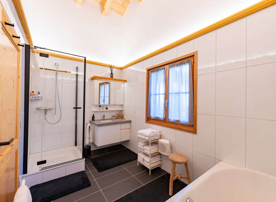 Experience modern comfort in this beautifully appointed bathroom, featuring a spacious glass-enclosed shower and a sleek vanity with ample storage.