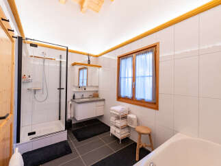 Experience modern comfort in this beautifully appointed bathroom, featuring a spacious glass-enclosed shower and a sleek vanity with ample storage.