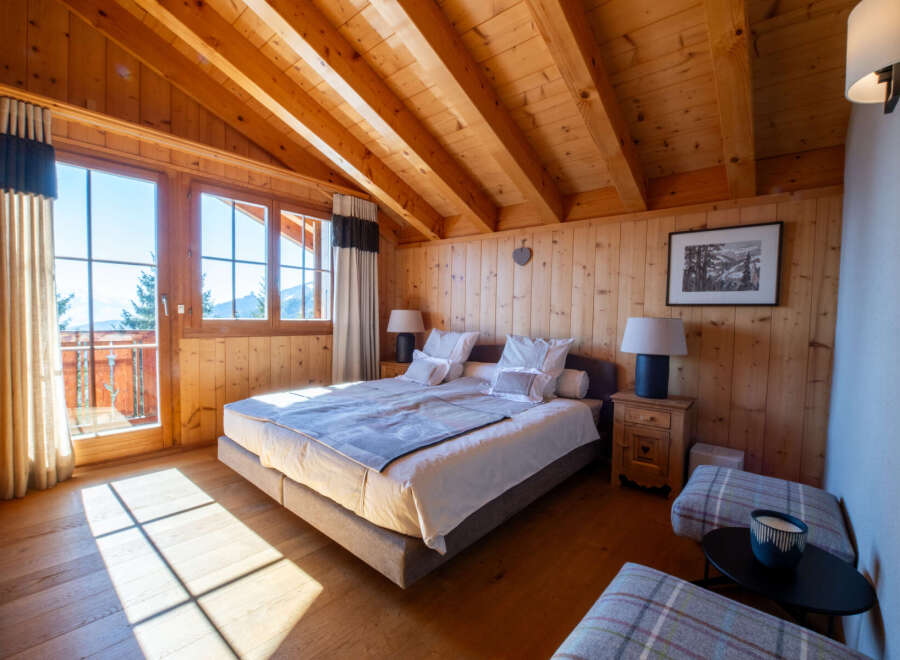 Experience rustic charm and breathtaking mountain views in this cozy alpine bedroom.