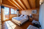 Experience rustic charm and breathtaking mountain views in this cozy alpine bedroom.
