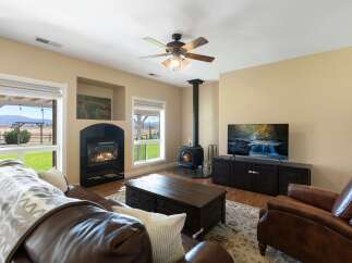 Experience cozy living in this inviting living room, featuring a beautiful gas fireplace and a charming wood-burning stove for warmth and ambiance.