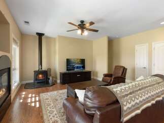 Cozy up by the fireplace in this inviting living room, featuring a modern wood-burning stove and a traditional fireplace.