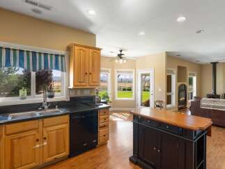 This spacious kitchen boasts ample natural light from large windows overlooking a scenic landscape.