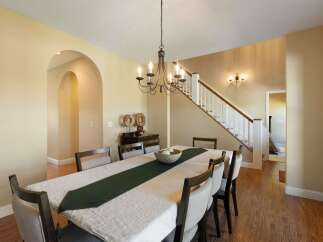 This elegant dining room features a large table set for a meal, complete with a decorative runner and centerpiece.