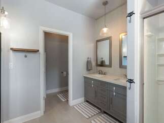 This spacious bathroom features a double vanity with ample storage and elegant fixtures, perfect for busy mornings.