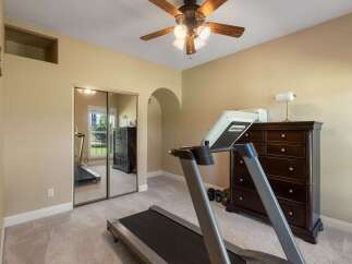 This room is set up as a home gym, featuring a treadmill and a set of dumbbells.