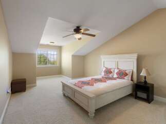 Discover comfort and style in this charming bedroom featuring a plush queen-size bed adorned with a decorative quilt and matching pillows.