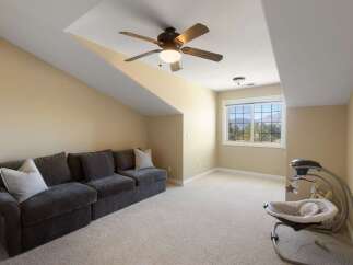This spacious room features a comfortable dark gray sectional sofa with light-colored accent pillows, perfect for relaxation.