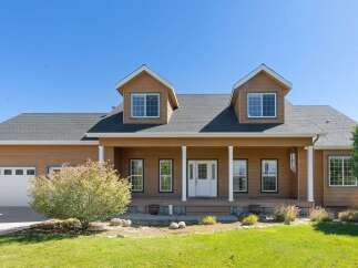 Charming home featuring a welcoming covered porch with white columns, perfect for enjoying the outdoors.