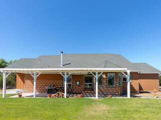 Enjoy outdoor living with this spacious backyard featuring a covered patio perfect for entertaining.