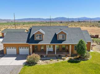 Discover this charming wood-sided home featuring a spacious wrap-around porch perfect for enjoying the scenic views.