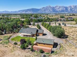 Experience serene living with this stunning property, boasting a spacious home with a covered porch perfect for enjoying the picturesque mountain views.