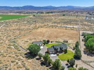 Discover this expansive rural property featuring a charming home with a welcoming front porch and attached garage.