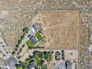 Discover this expansive property featuring a main residence, a detached garage, and a vast, cultivated field perfect for agricultural pursuits or future development.