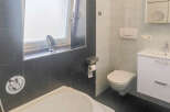 This modern bathroom features a sleek design with a deep soaking tub and a separate shower area.