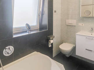 This modern bathroom features a sleek design with a deep soaking tub and a separate shower area.