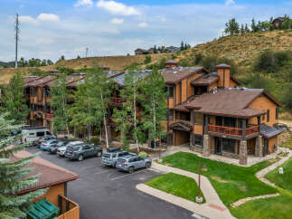Discover this charming mountain property featuring a multi-story building with attractive wood siding and stone accents.