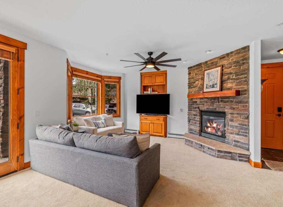 Cozy living room featuring a stone fireplace with a roaring fire, perfect for chilly evenings.