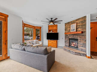 Cozy living room featuring a stone fireplace with a roaring fire, perfect for chilly evenings.