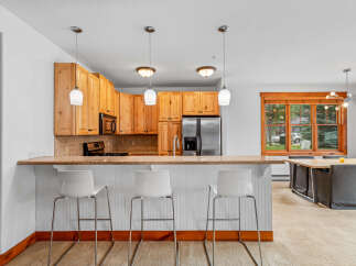 This inviting kitchen features warm wood cabinetry and a granite-topped breakfast bar, perfect for casual dining.