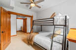 This charming bedroom features a space-saving bunk bed with comfortable white bedding and decorative throw pillows.