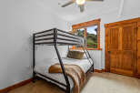 This cozy bedroom features a sturdy black metal bunk bed with white linens, perfect for accommodating guests or children.